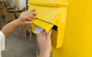 Manos metiendo una carta en un buzón