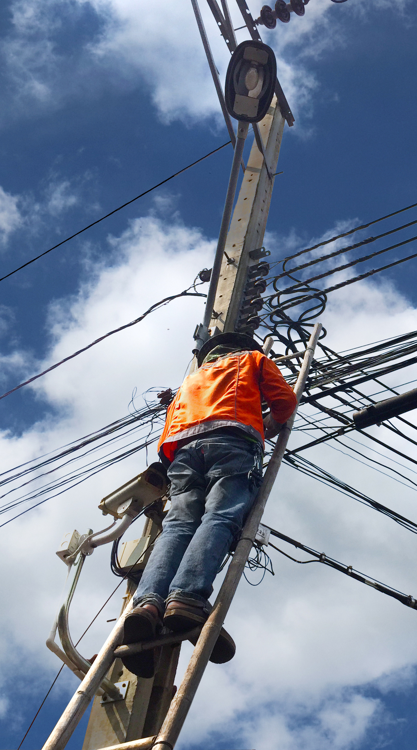 Hombre trabajando en un poste de telecomunicaciones