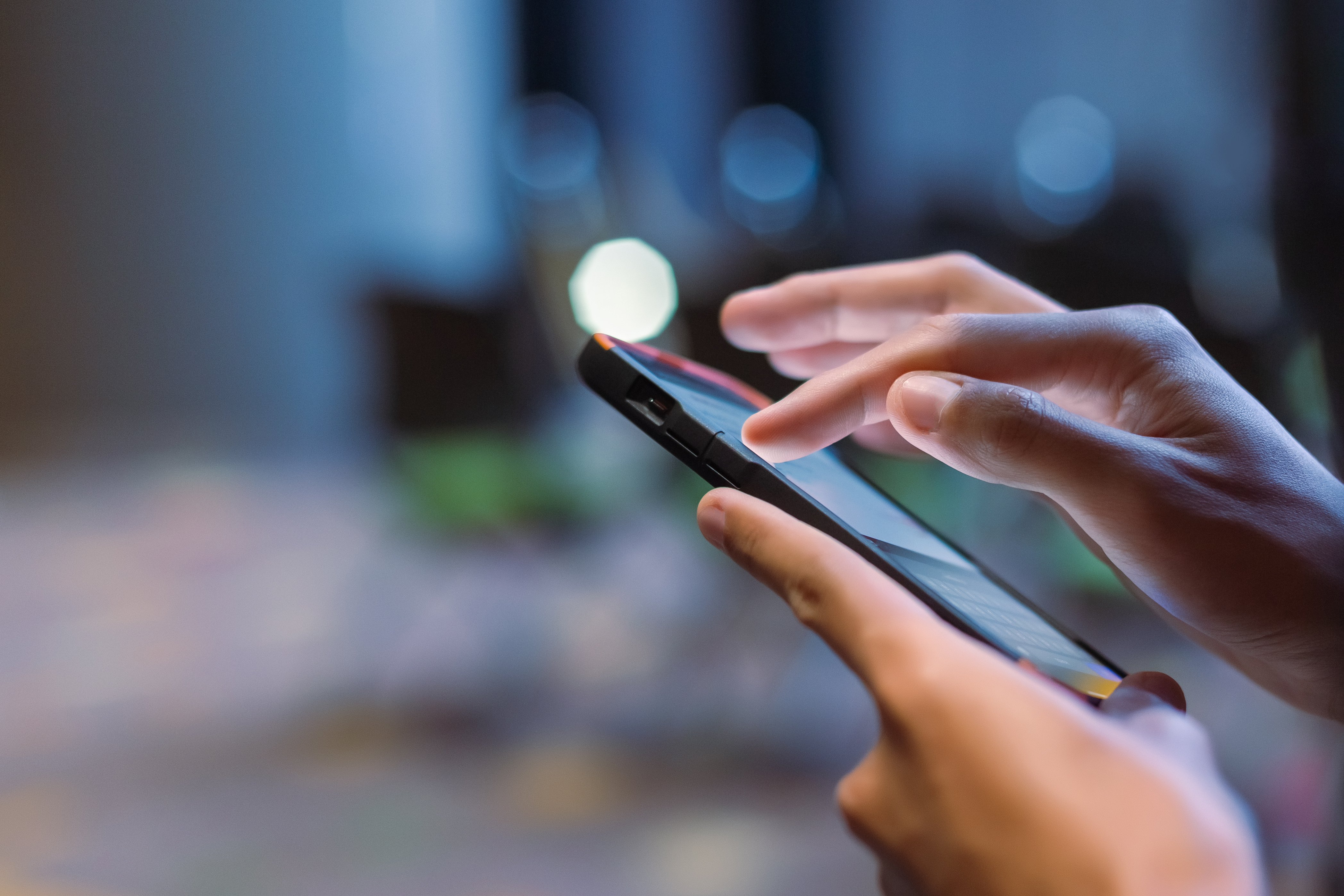 Mano tecleando en una pantalla móvil